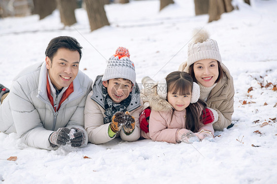 趴在雪地里玩耍的快乐家庭图片