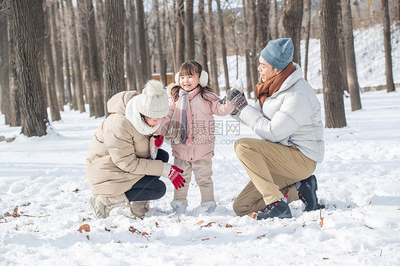 一家三口在雪地里玩耍图片