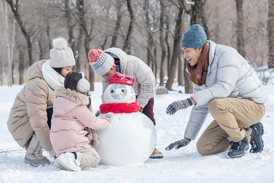 欢乐家庭在雪地里堆雪人图片