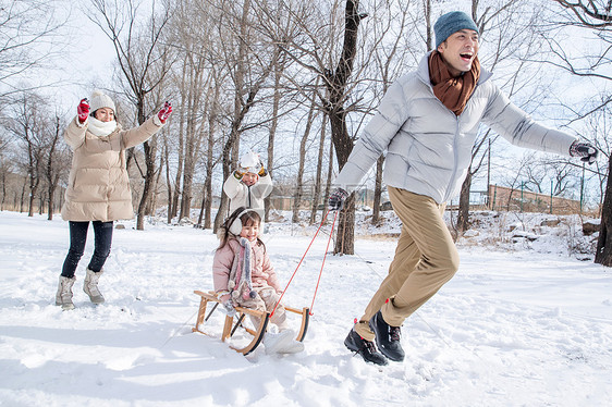 欢乐家庭在雪地上玩雪橇图片