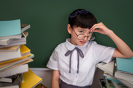 孩子与书坐在书堆里的小学女生背景