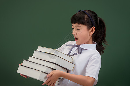 小学女生抱着一堆书背景图片