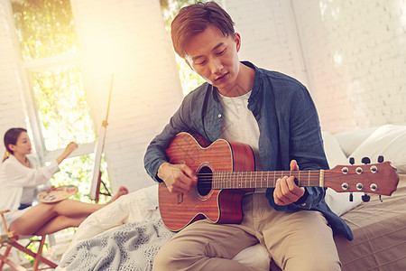 青年男人在家弹吉他图片