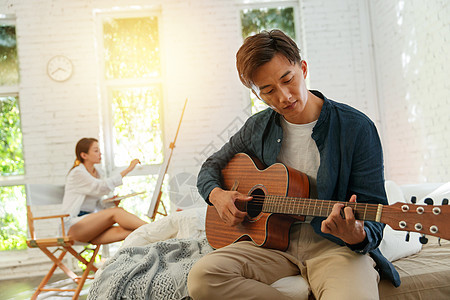 青年男人在家弹吉他图片