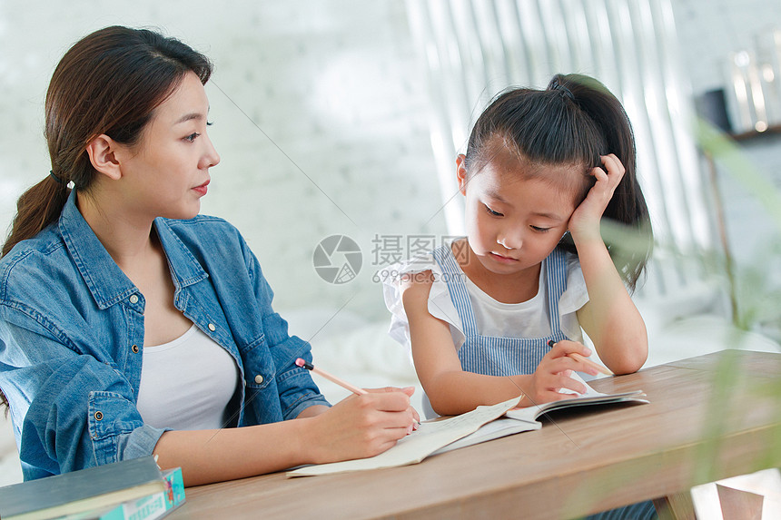 辅导女儿做作业的青年女人高清图片下载-正版图片507668839-摄图网