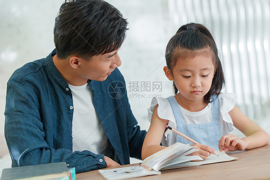 辅导女儿做作业的青年男人高清图片下载-正版图片507668852-摄图网