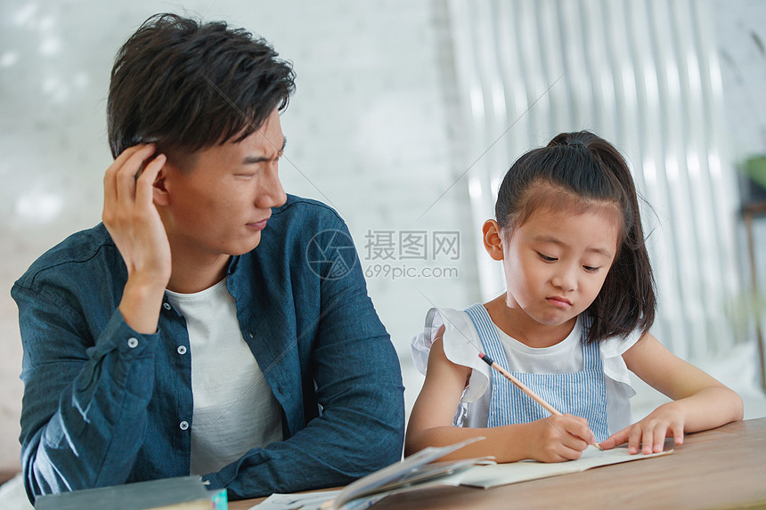 辅导女儿做作业的青年男人高清图片下载-正版图片507668884-摄图网