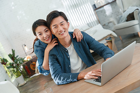 快乐的青年伴侣使用笔记本电脑图片