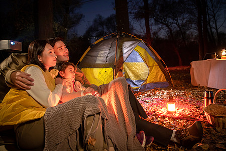 幸福的三口之家夜晚在户外露营图片