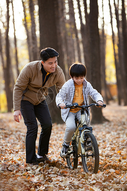 快乐的父亲教儿子骑自行车图片