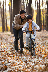 幸福的父亲教儿子骑自行车图片