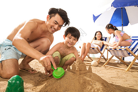 幸福家庭在沙滩上玩耍图片