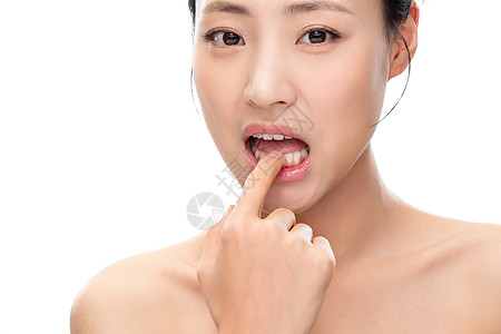 清洁皮肤用手指触碰牙齿的青年女人背景
