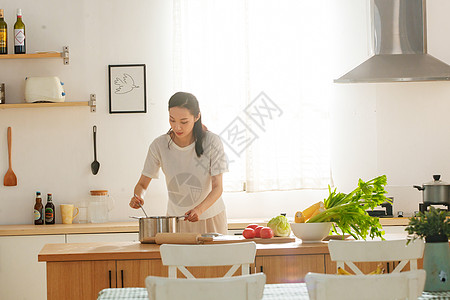 青年女人在厨房里做饭图片