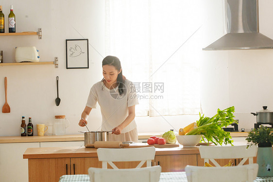 青年女人在厨房里做饭图片