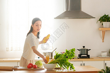 青年女人在厨房里做饭图片