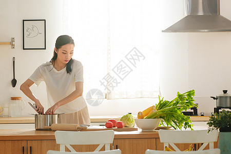 青年女人在厨房里做饭图片