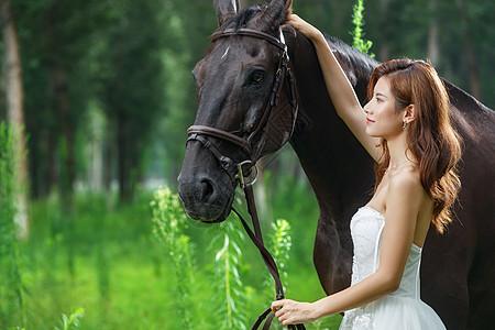 时尚的青年女人和骏马图片