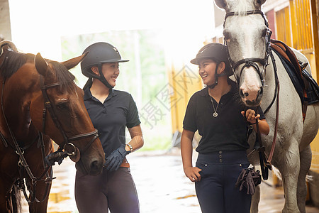 马厩里牵着马的快乐姐妹俩图片
