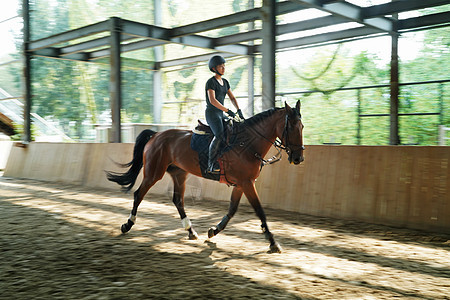 马场上骑马奔跑的年轻女子图片