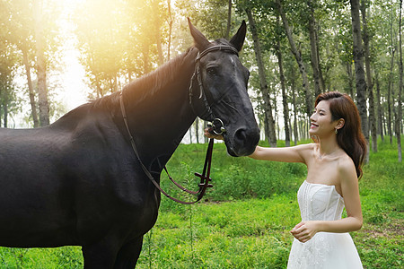 微笑美女户外漂亮的青年女人牵着马背景