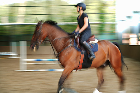 马场上骑马奔跑的年轻女子图片