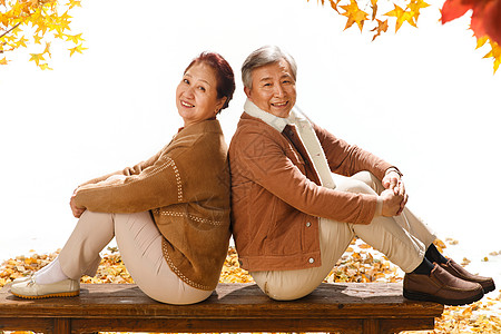 老长凳和落叶快乐的老年夫妇背景