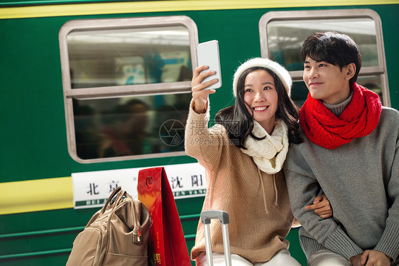 在火车站台上的青年情侣看手机图片