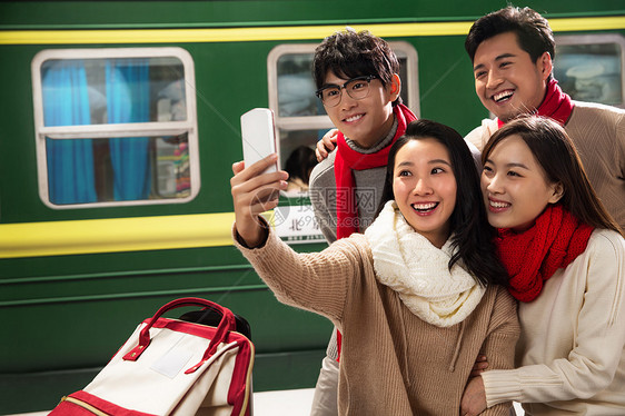 青年男女在火车站台上用手机图片