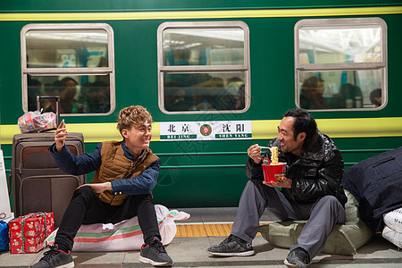 交通技术两名男子在火车月台上看手机背景