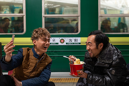 月子服两名男子在火车月台上看手机背景