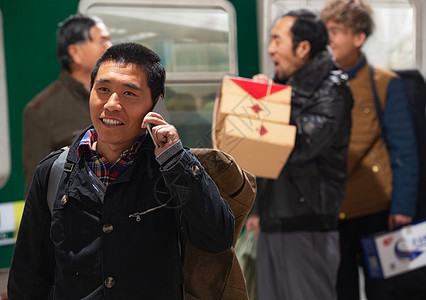 站在火车月台上打电话的旅客图片