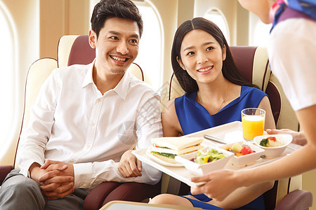 年轻夫妇在飞机上用餐图片