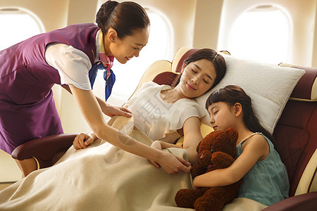 睡觉的小女孩乘务员给乘客盖毯子背景