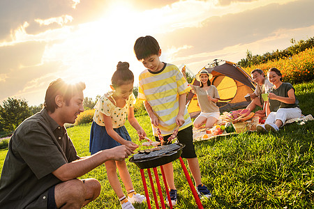 儿童夏令营欢乐的一家人在郊外野餐烧烤背景