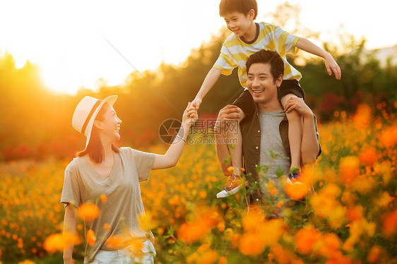 幸福的一家三口站在花丛中图片