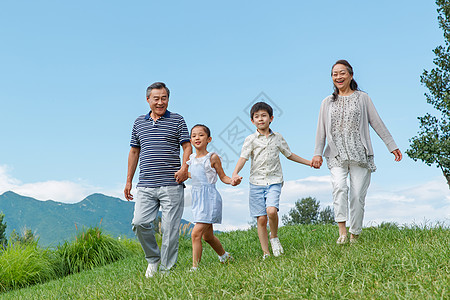 孩子们手牵手幸福老人和孩子们在草地上玩耍背景