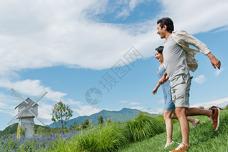 浪漫夫妇手牵手在草地上奔跑图片