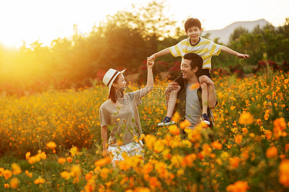 幸福的一家三口站在花丛中图片