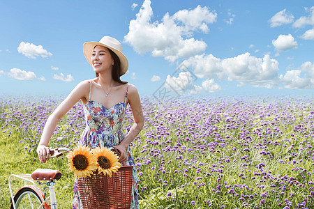 在花海里骑自行车的青年女人图片