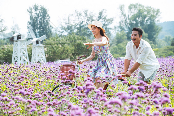 青年夫妇在花海里骑车图片