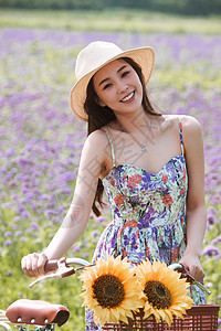 青年女人在花海里骑自行车图片