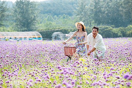 青年夫妇在花海里骑车图片