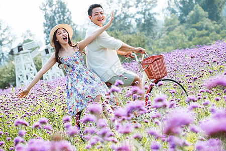 青年夫妇在花海里骑车图片