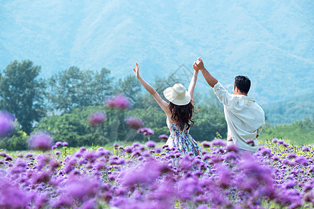 紫色裙子浪漫夫妇站着花海里背景