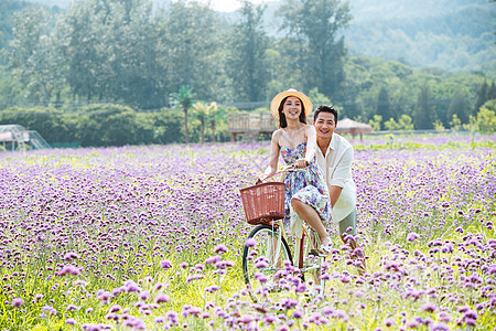 青年夫妇在花海里骑车图片