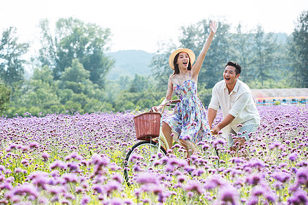 青年夫妇在花海里骑车图片