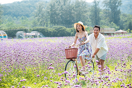 青年夫妇在花海里骑车图片