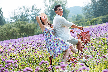 青年夫妇在花海里骑车图片