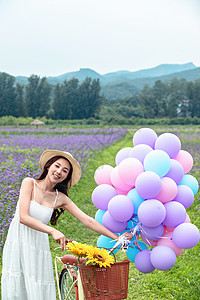 青年女人在花海里骑自行车图片